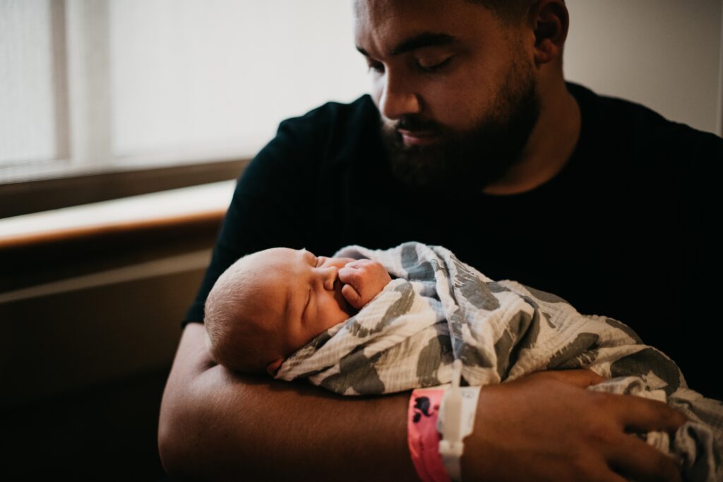 father holding newborn baby in hospital