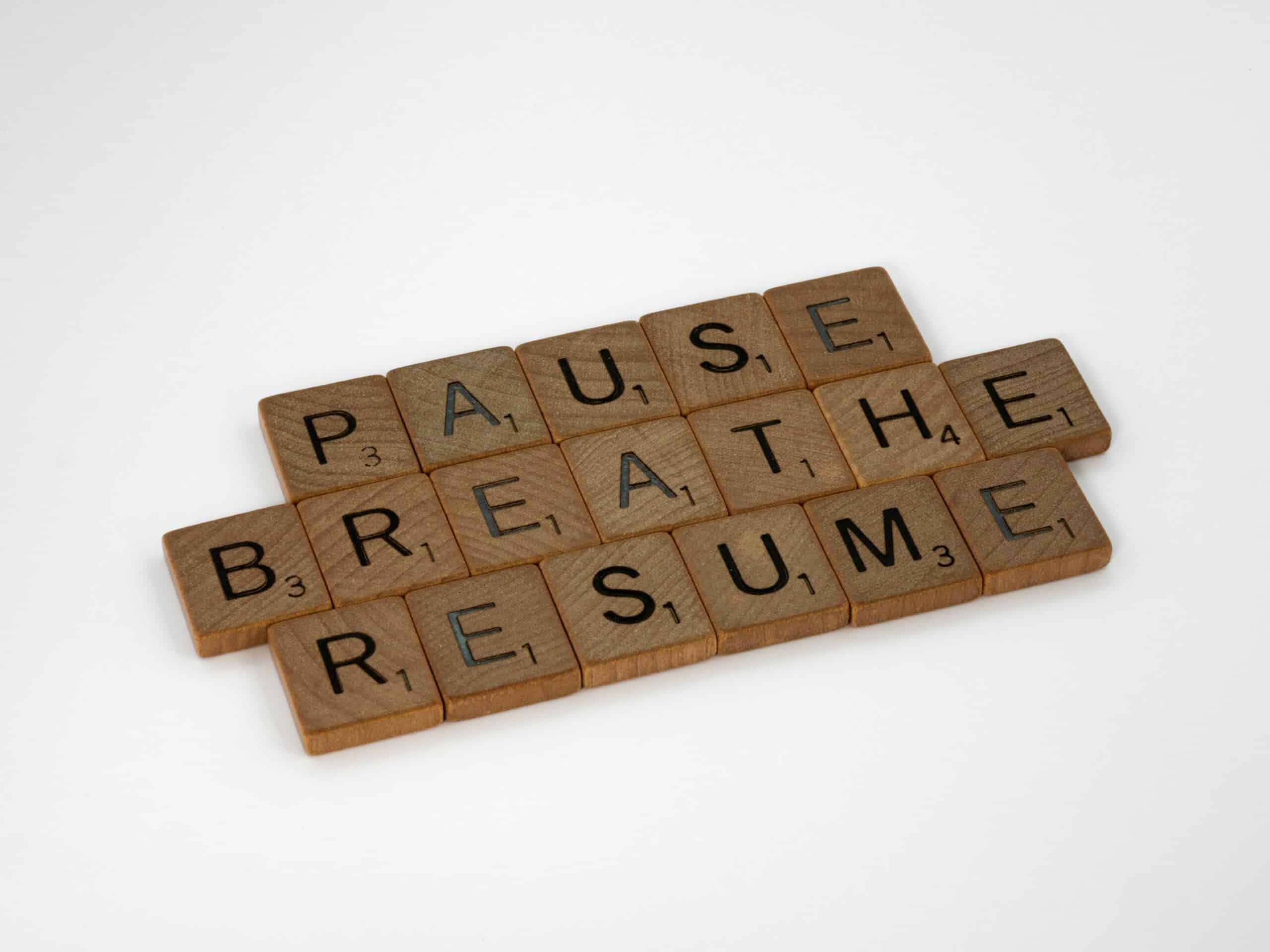 brown word tiles on white background reading pause breathe resume