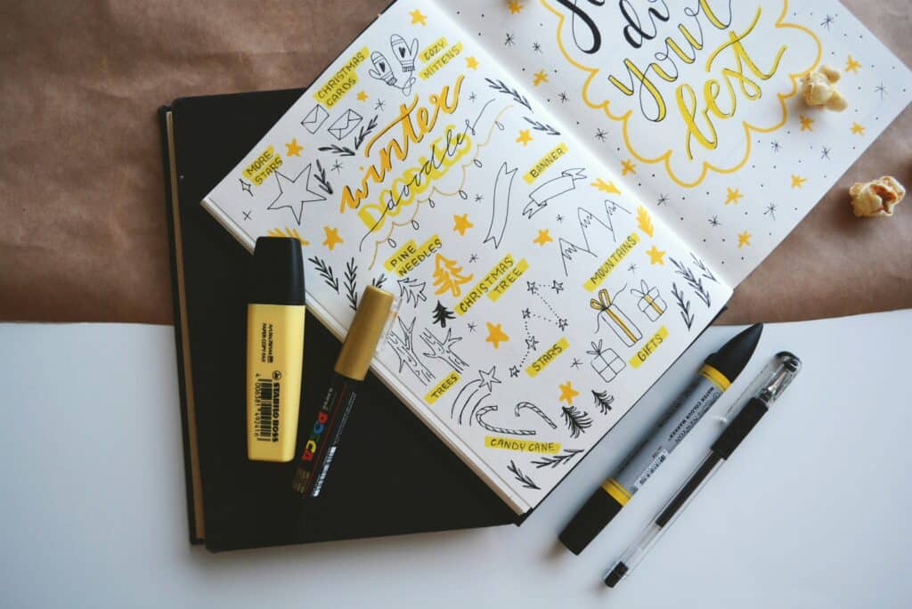 Pens and journal with black and yellow doodles
