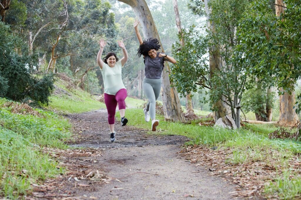 Two women joyfully romping through the woods