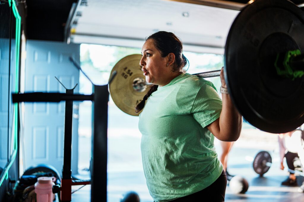 woman lifting weights in a green shirt
